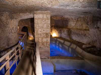 Le vasche scavate ai nostri piedi, oggi vuote e illuminate da una forte luce blu, un tempo erano probabilmente gli spazi in cui si raccoglievano le riserve di acqua